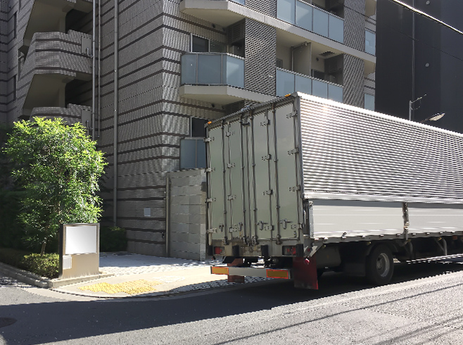 マンションの前に停車した引越しトラックの画像